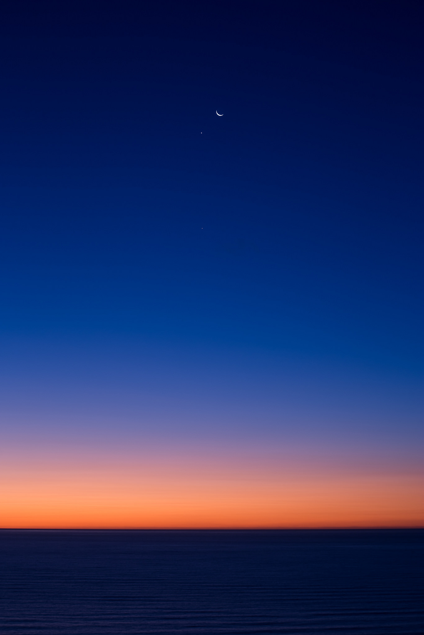 The moon, Venus to the left and Jupiter below.