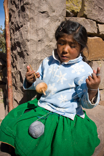 A young girl spinning wool